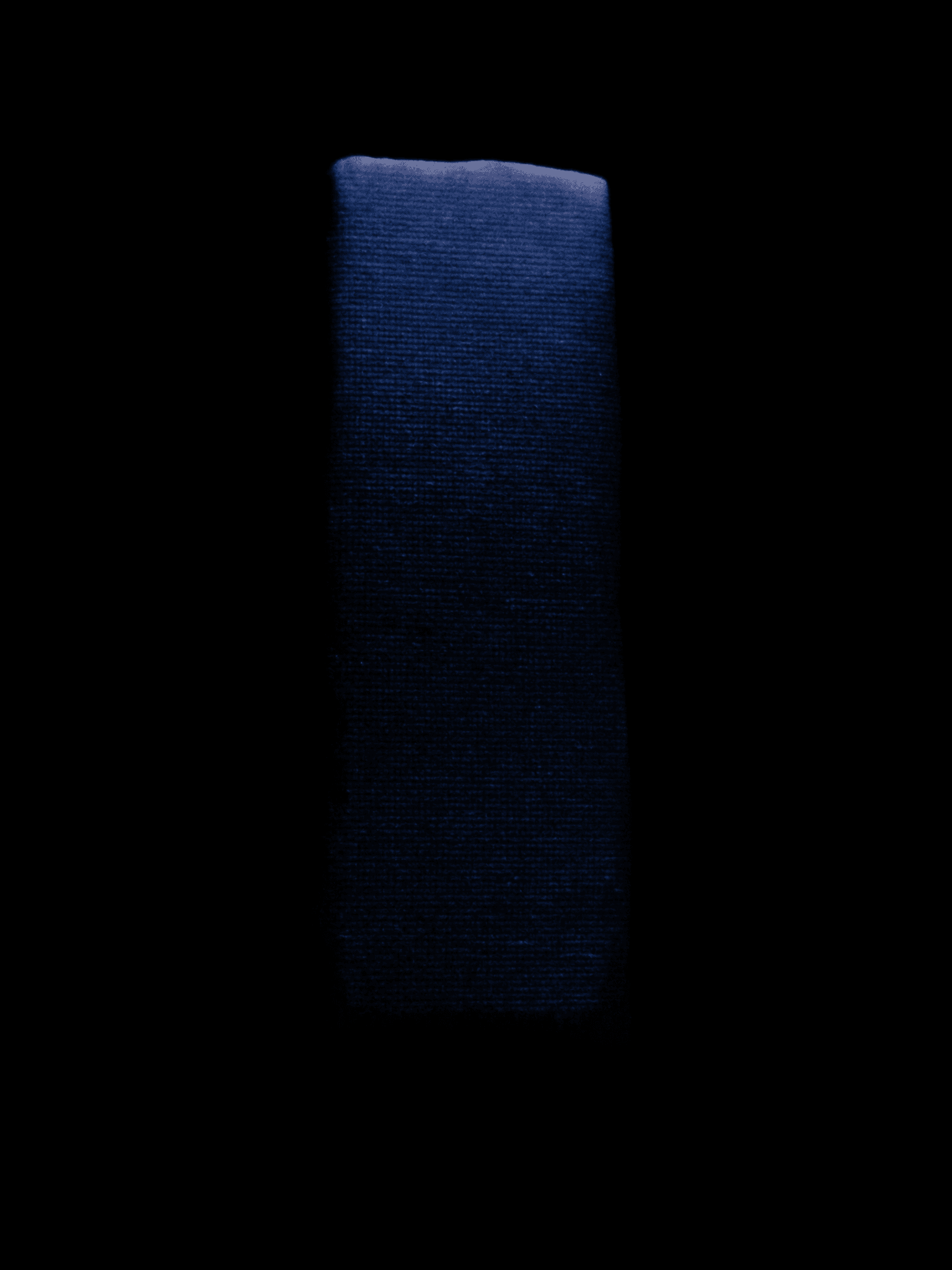Matte black monolith engraved with a faint glowing grid